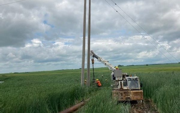 Manitoba Hydro workers repairing a hydro pole in 2022.