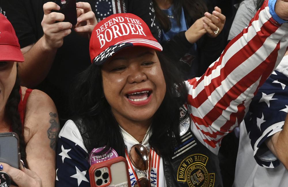 Mimi Israelah, center, cheers for Donald Trump inside the Alaska Airlines Center in Anchorage, Alaska, during a rally Saturday July 9, 2022. An investigation has been launched after a person believed to be an Anchorage, Alaska, police officer was shown in a photo with Israelah flashing a novelty “White Privilege card.” The social media post caused concerns about racial equality in Alaska’s largest city.