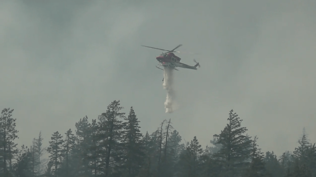 A helicopter drops water on the Nohomin Creek wildfire near Lytton, B.C.