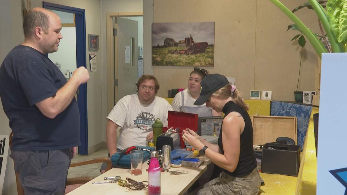 Brendan Hood (left), co-founding director of the Lethbridge Tool Library, teaches members how to split a nut at the Brews and Screws café. July 23.