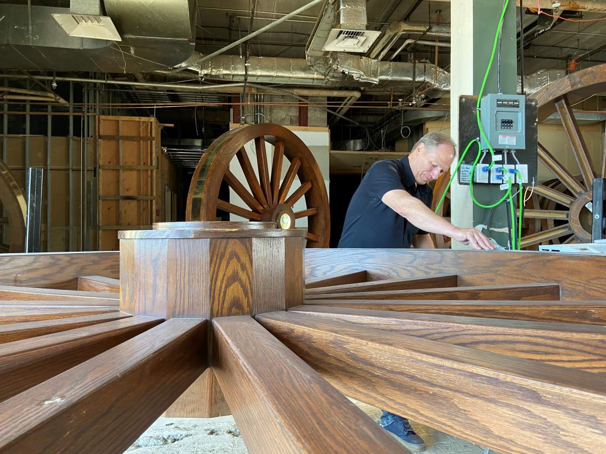 Don Delaney sanding and staining old wagon wheels.