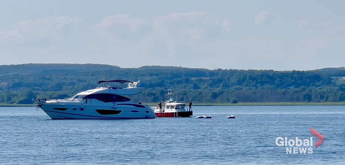 Crews tend to a yacht struck by a power boat on Lake Ontario near Brighton on July 16, 2022.