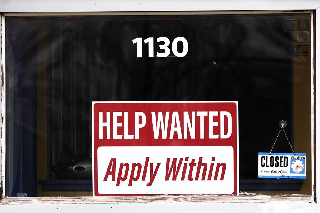 FILE - A 'help wanted' sign is seen at an Allstate insurance office in Elgin, Ill., March 19, 2022.