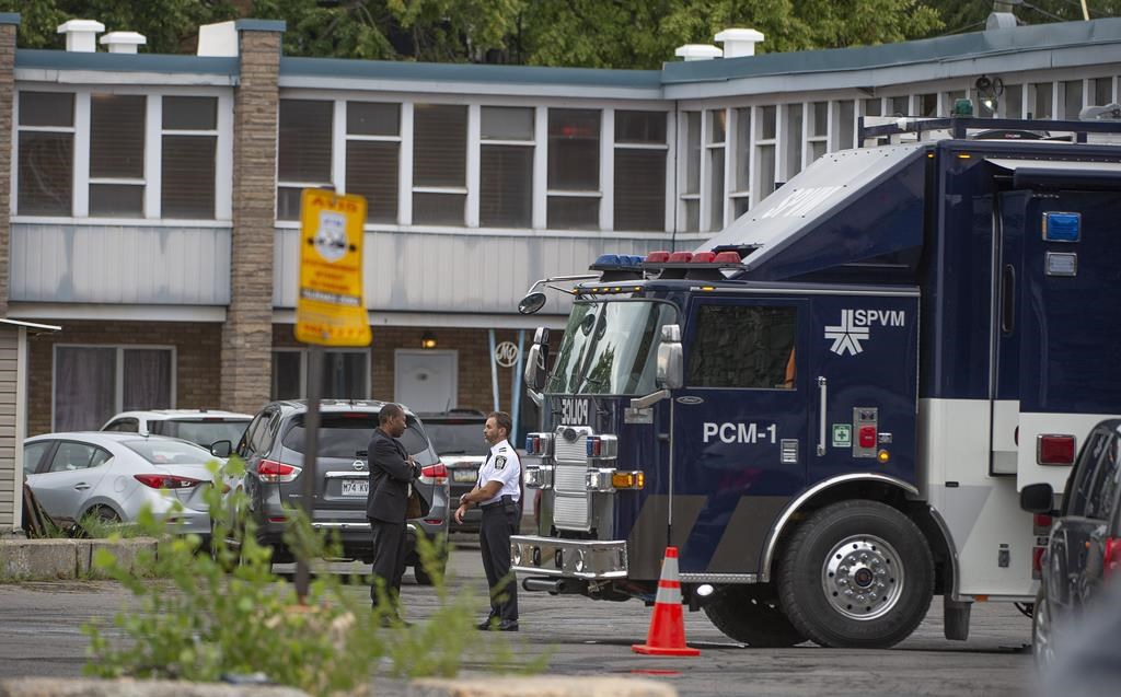 Police investigators at the scene where a 26-year-old man was killed after being shot by Montreal police in the parking lot of a motel in the city's St-Laurent borough on Aug. 4, 2022.