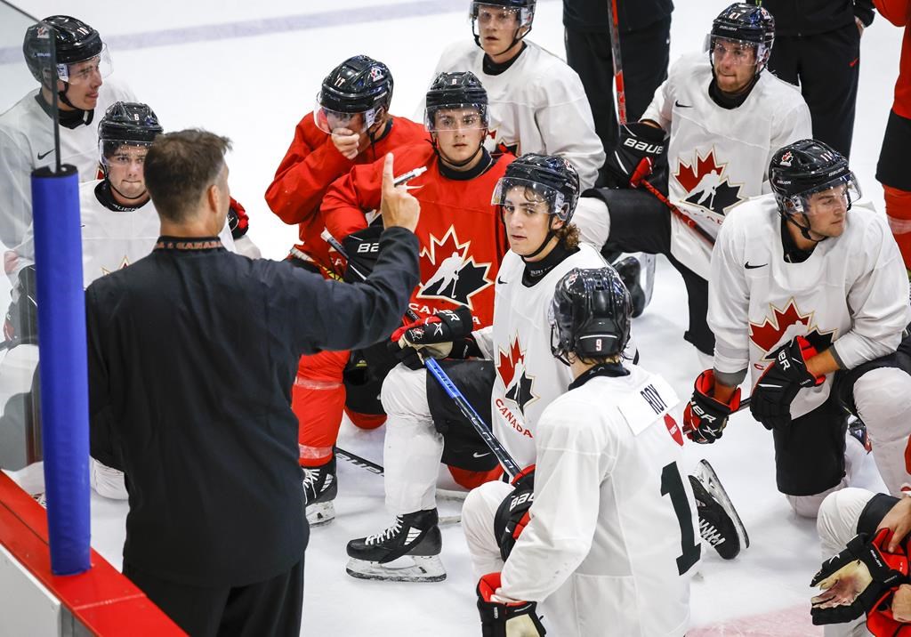 Canada’s National Junior Team assistant coach Michael Dyck, left, gives instructions during a training camp practice in Calgary, Tuesday, Aug. 2, 2022.