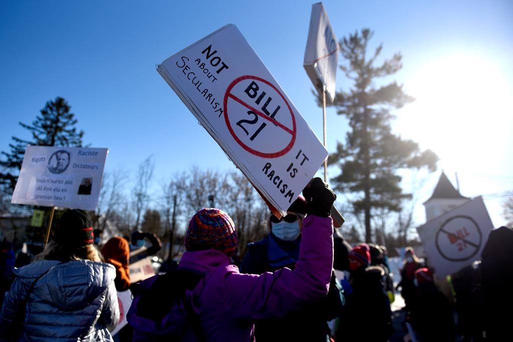 People rally against Quebec’s Bill 21, which prohibits some public sector workers from wearing religious symbols at work, after a teacher was removed from her position because she wears a hijab, in Chelsea, Que., on Tuesday, Dec. 14, 2021. A new survey has found that religious minorities in Quebec are feeling less safe, less accepted and less hopeful since the province passed its secularism law three years ago.THE CANADIAN PRESS/Justin Tang.