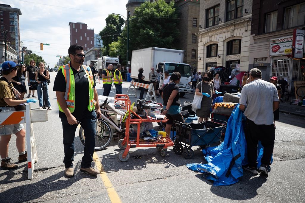 A person's belongings are placed on the street to be moved to storage after his tent was cleared from the sidewalk at a sprawling homeless encampment on East Hastings Street in the Downtown Eastside of Vancouver, on Tuesday, August 9, 2022. 