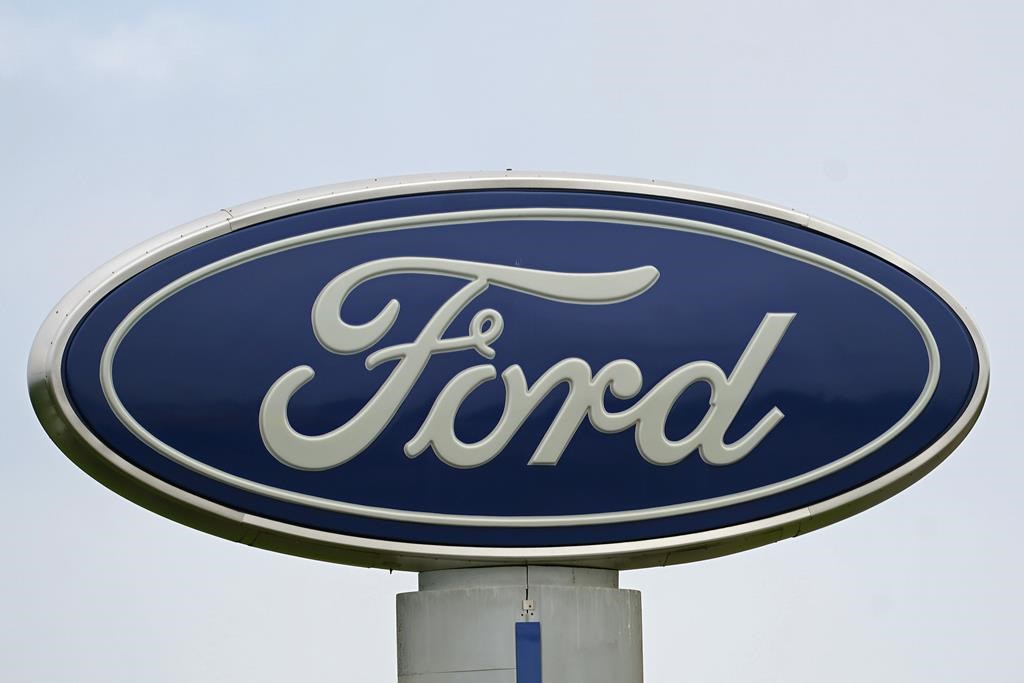 FILE - A Ford logo is seen on signage at Country Ford in Graham, N.C., Tuesday, July 27, 2021. Ford Motor Co. is cutting about 3,000 white-collar workers as it moves reduce costs and make the transition from internal combustion to electric vehicles, leaders of the Dearborn, Mich., automaker announced Monday, Aug. 22, 2022, in a companywide email. (AP Photo/Gerry Broome, File).