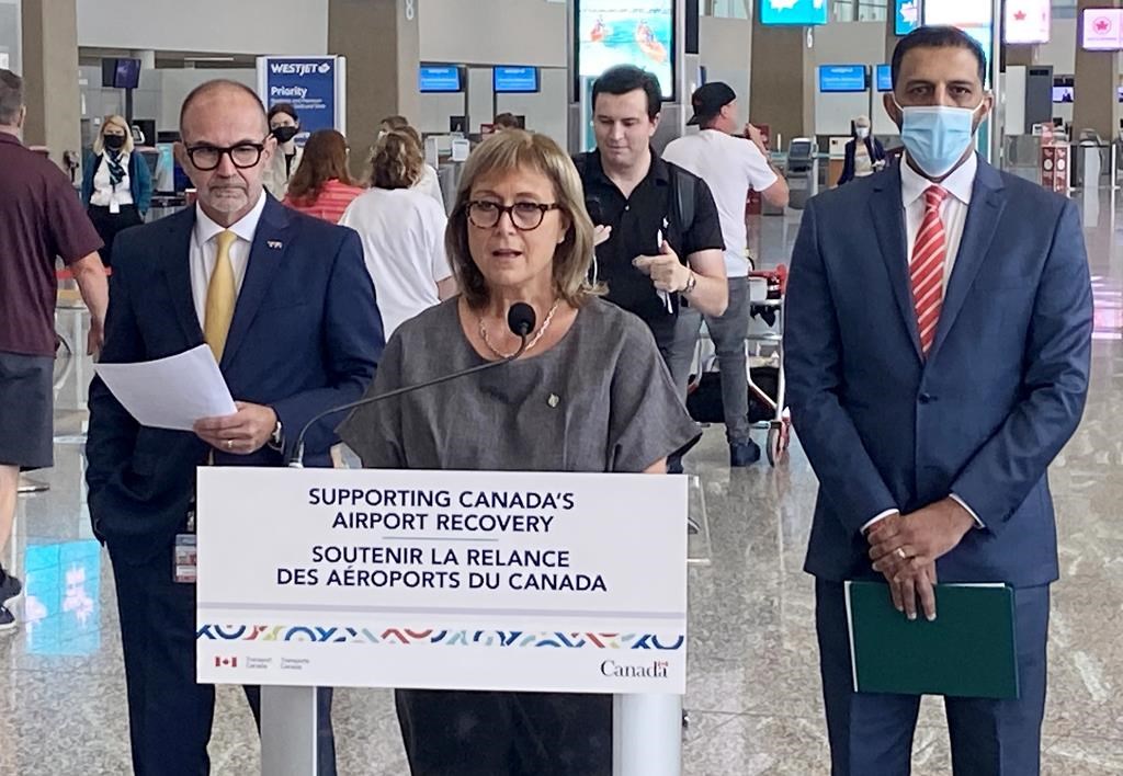 Parliamentary Secretary for Transport and Liberal MP Annie Koutrakis, centre, speaks as Calgary Airport Authority CEO Bob Sartor, left, and Liberal MP George Chahal look on during a funding announcement in Calgary on Tuesday, August 23, 2022.