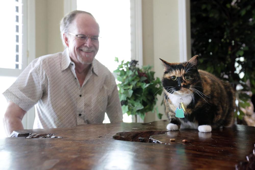 Fred Everitt of Tupelo, Miss., is all smiles after his cat, "Bandit", alerted him in the middle of the night that two men were trying to break into the back door of his home, July 29, 2022, in Tupelo, Miss.