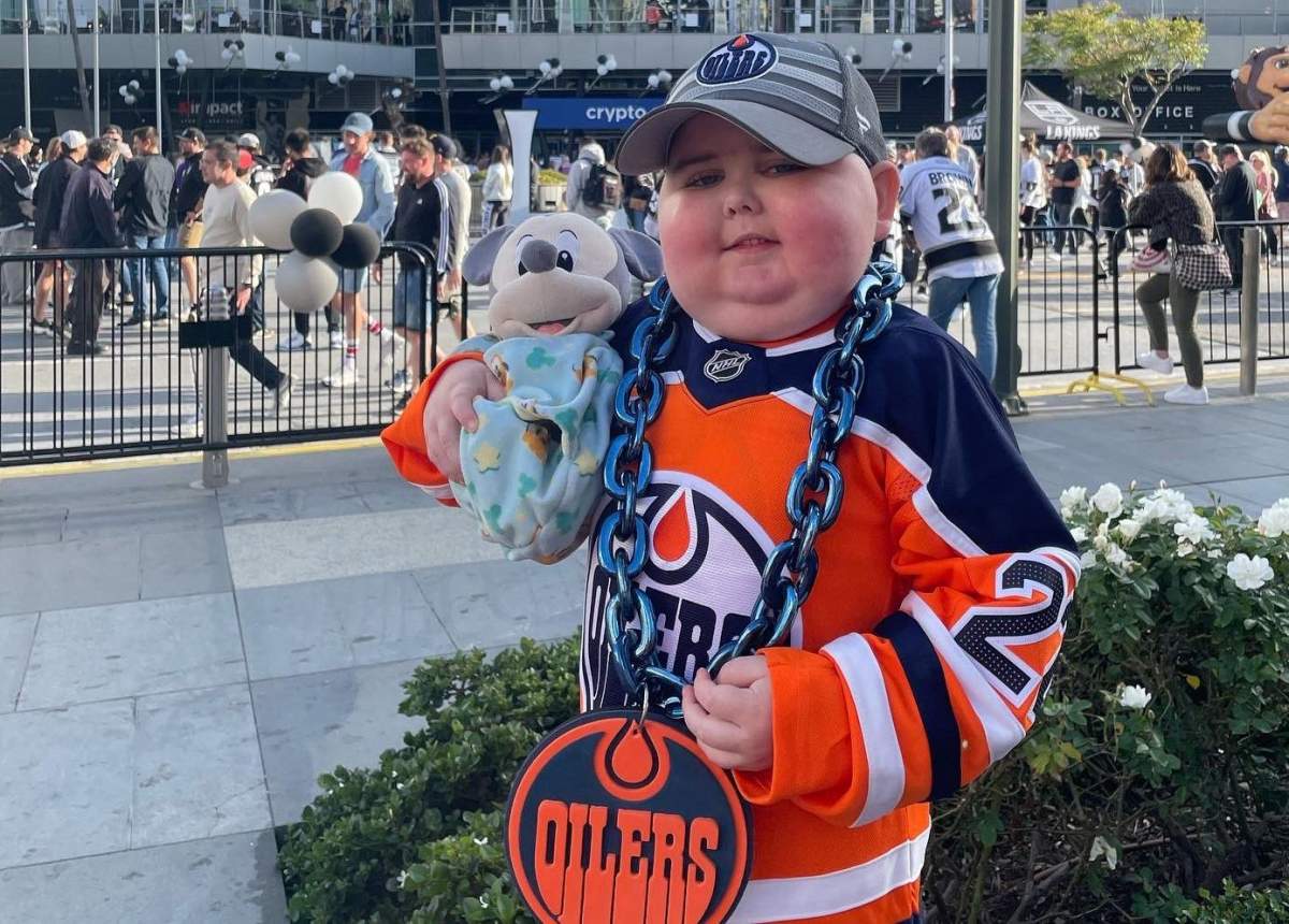 Ben Stelter, a young Edmonton Oilers fan with cancer, poses with Connor McDavid in the team's locker room earlier in 2022.