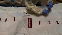 A nurse attaches "COVID Patient" stickers on a body bag of a patient who died of coronavirus at Providence Holy Cross Medical Center in Los Angeles, Dec. 14, 2021