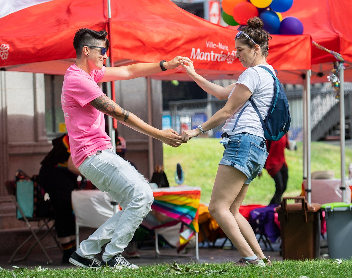 Florence, left, and Billie dance at the site where the Montreal Pride parade was supposed to start from in Montreal, Sunday, August 7, 2022. Festival organizers cancelled the parade over concerns for security due to the lack of staff. 