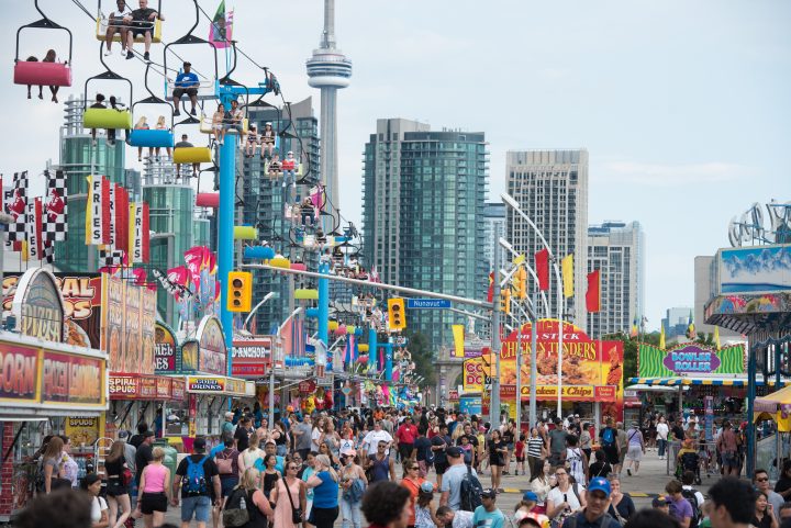 Crowds make their way through the midway during opening day of the Canadian National Exhibition in Toronto on Friday, August 19, 2022.  