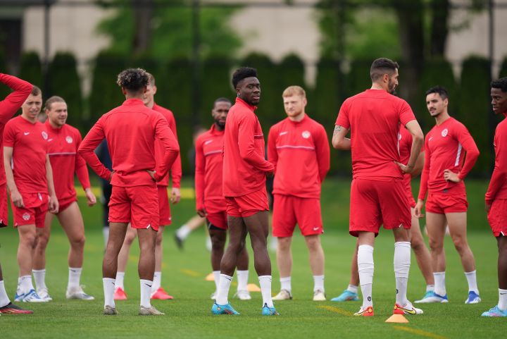 Canadian national men's soccer team forward Alphonso Davies, centre, stands with his teammates during a training session for a CONCACAF Nations League match against Curacao, in Vancouver, on Tuesday, June 7, 2022. 