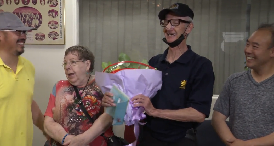 Veteran Chinatown security guard Harold Johnson receives flowers and a donation on Aug. 22, 2022, in downtown Vancouver, 10 days after he was assaulted by a stranger while on-duty.