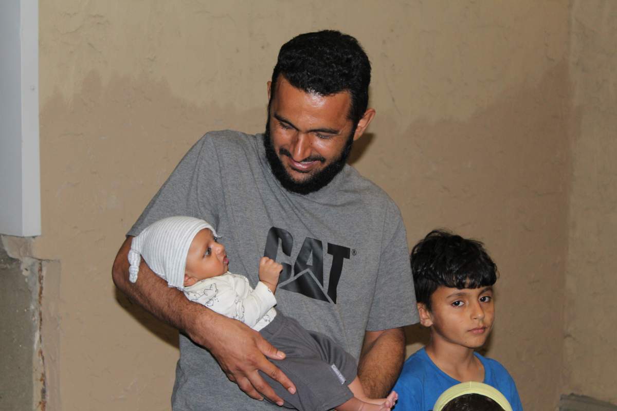 Bashir Ahmadi, who worked for the Canadian Forces in Kandahar, cradles his newborn son in Edmonton, Aug. 11, 2022.