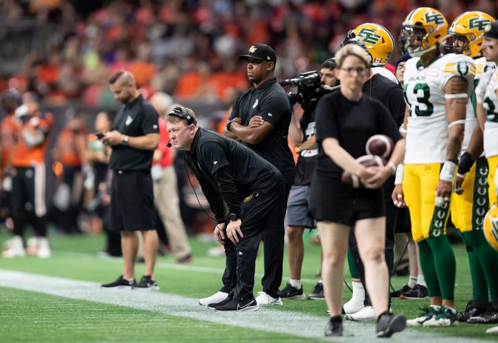 Edmonton Elks head coach Chris Jones, front centre, and assistant general manager Geroy Simon, back, watch from the sideline during the second half of CFL football game against the B.C. Lions in Vancouver, on Saturday, August 6, 2022. 