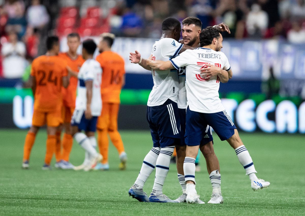 Lucas Cavallini of the Vancouver Whitecaps, middle, celebrates with teammates Tosaint Ricketts and Russell Teibert after he scored the game-winning goal against the Houston Dynamo during MLS action in Vancouver on Friday, August 5, 2022. 