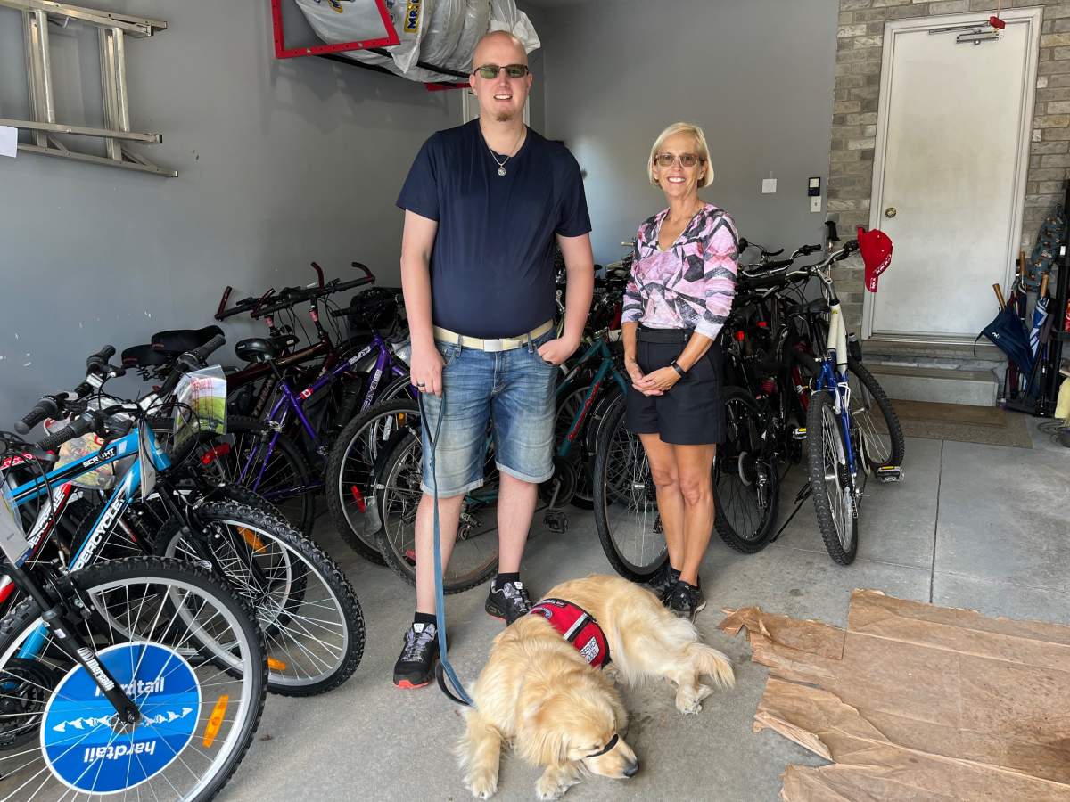 AJ and Heather McCallum stand in front of a dozens of yet-to-be fixed bikes inside a west London garage.