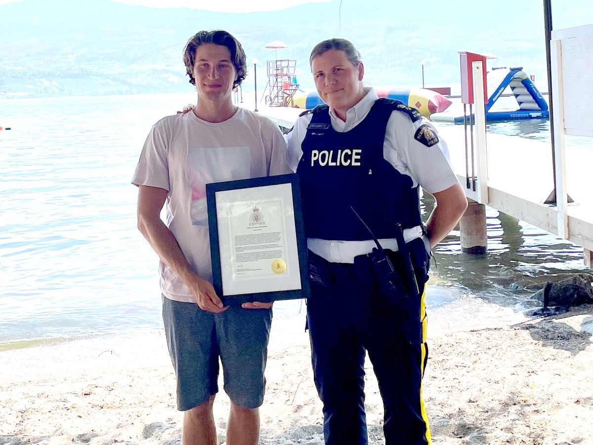Lifeguard Aiden Godwin, left, was commended by Kelowna RCMP Supt. Kara Triance for his bravery in late July after a boat crashed into a dock. A female was ejected into the water, with Godwin swimming to her through debris and leaking boat fuel. 