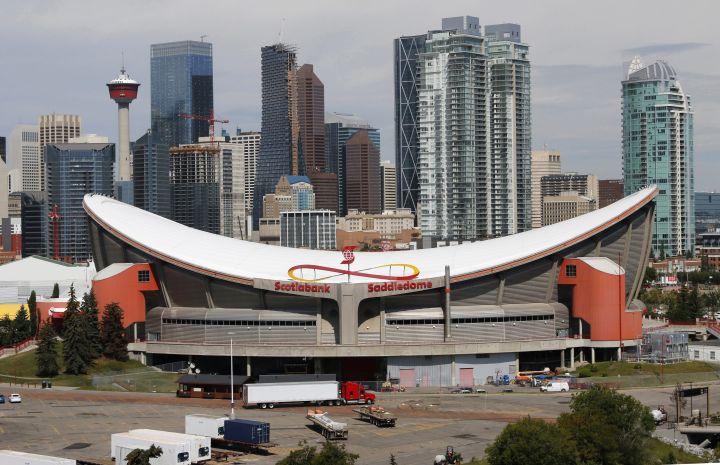 The Saddledome (home to the NHL Calgary Flames), in foreground, and the downtown city core area in Calgary, Alta. on July 30, 2019. 