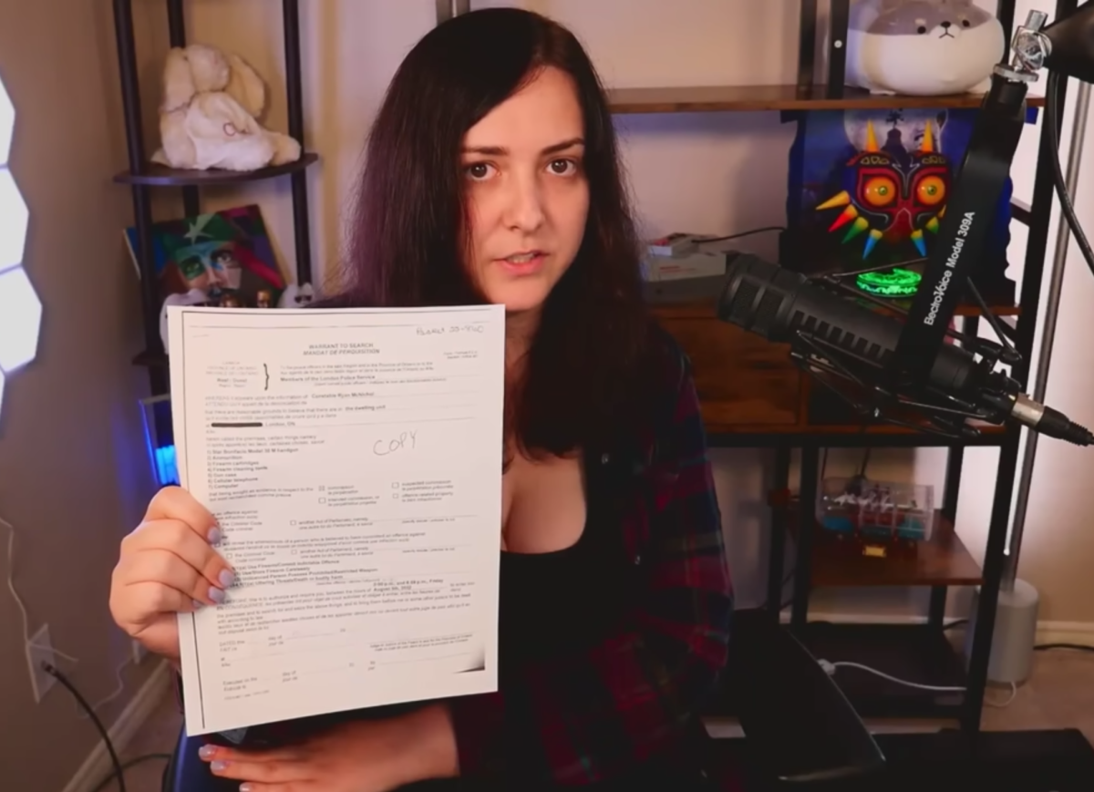 In a video posted to her YouTube page, Clara Sorrenti holds a copy of the search warrant obtained by police after a series of false