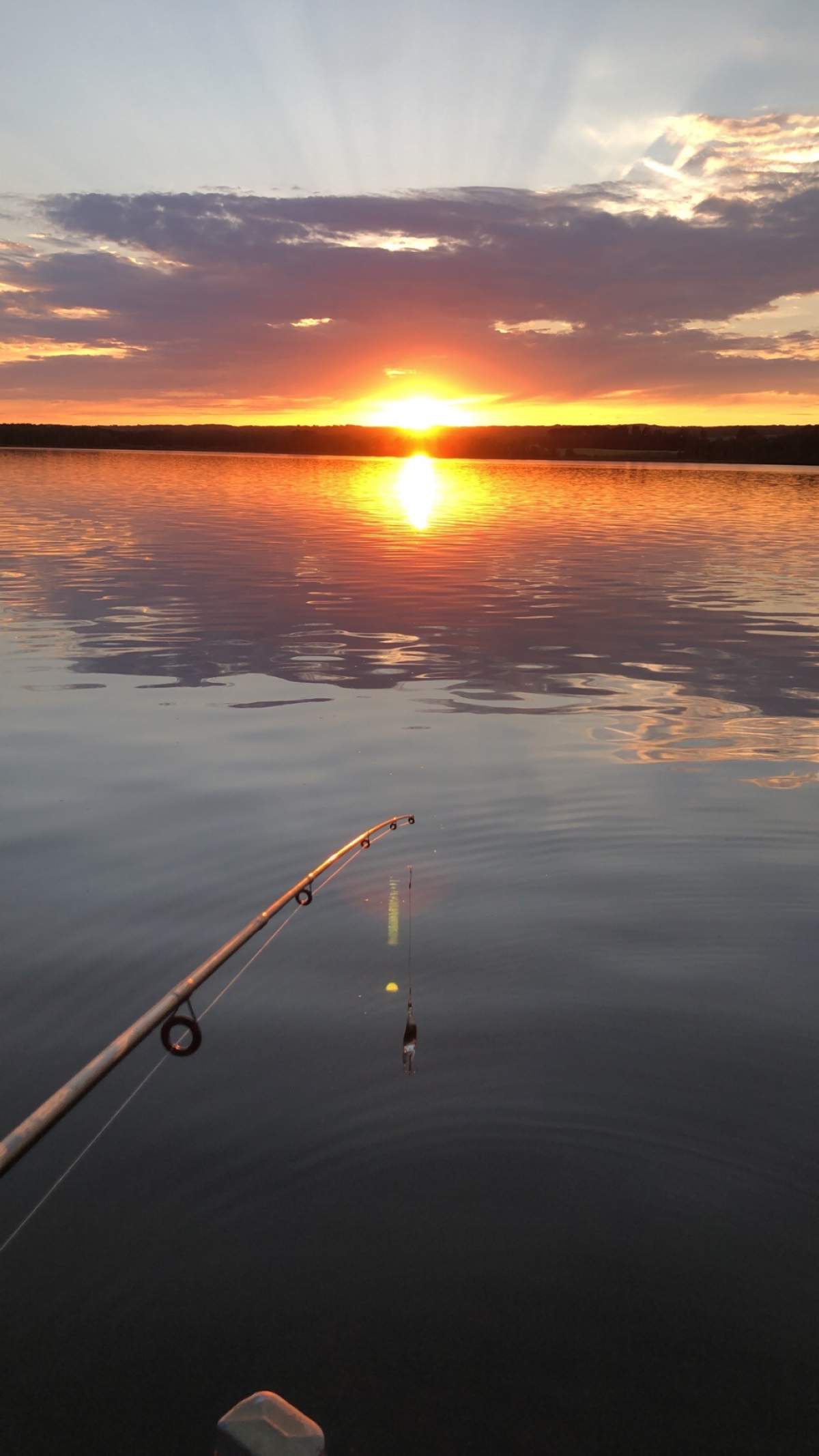 fishing at a lake overlooking sunset