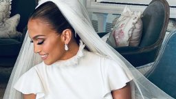 Jennifer Lopez sitting in a car in her custom Ralph Lauren gown with matching veil.