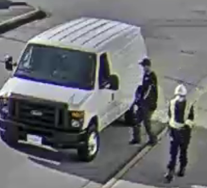 The two suspects pictured in a still photo with the white van they used to escape.