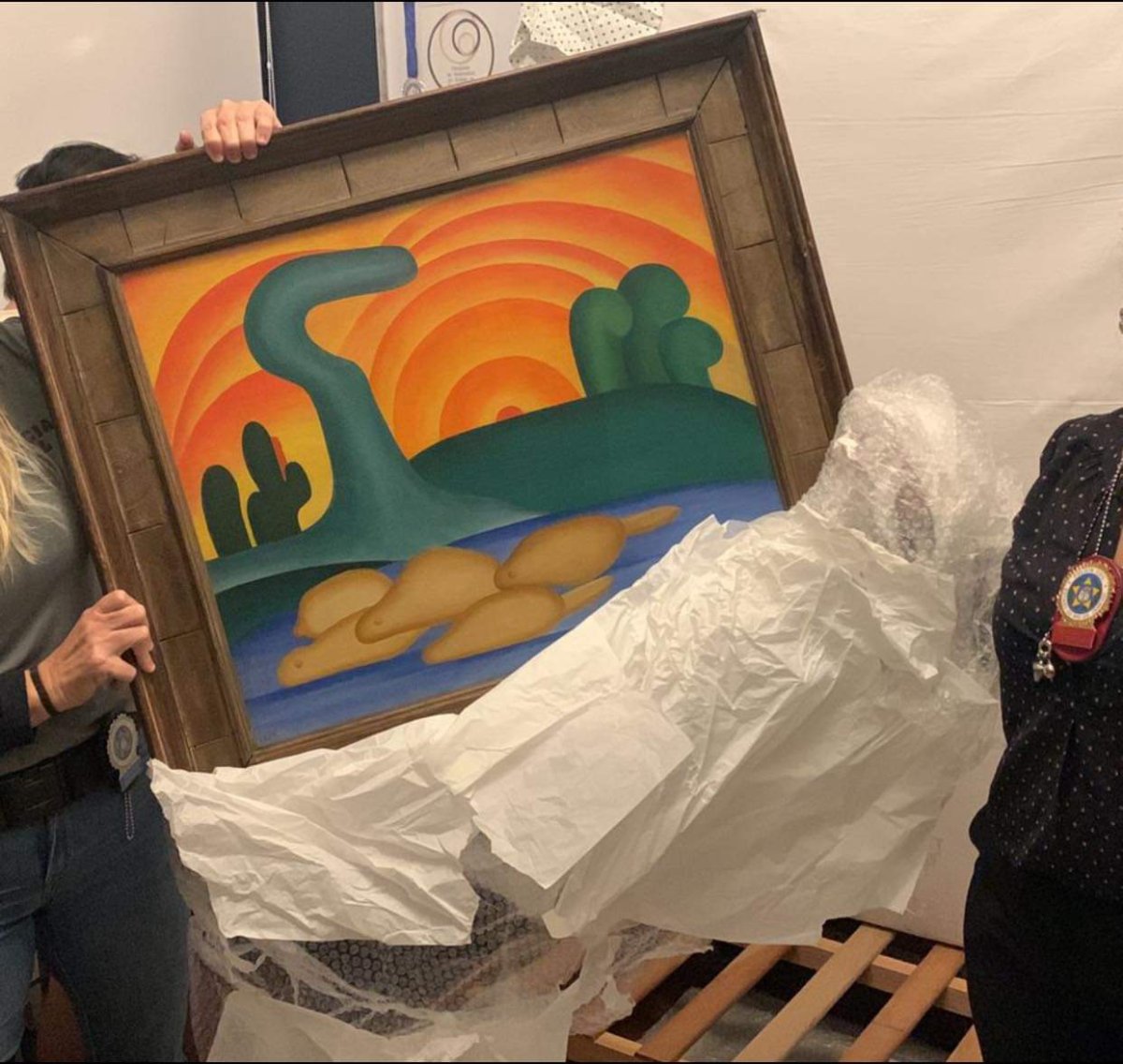 A photo shared by police in Rio de Janeiro showing the moment when two police officers recovered a precious piece of art that was stolen in an elaborate scheme orchestrated by the victim's daughter.