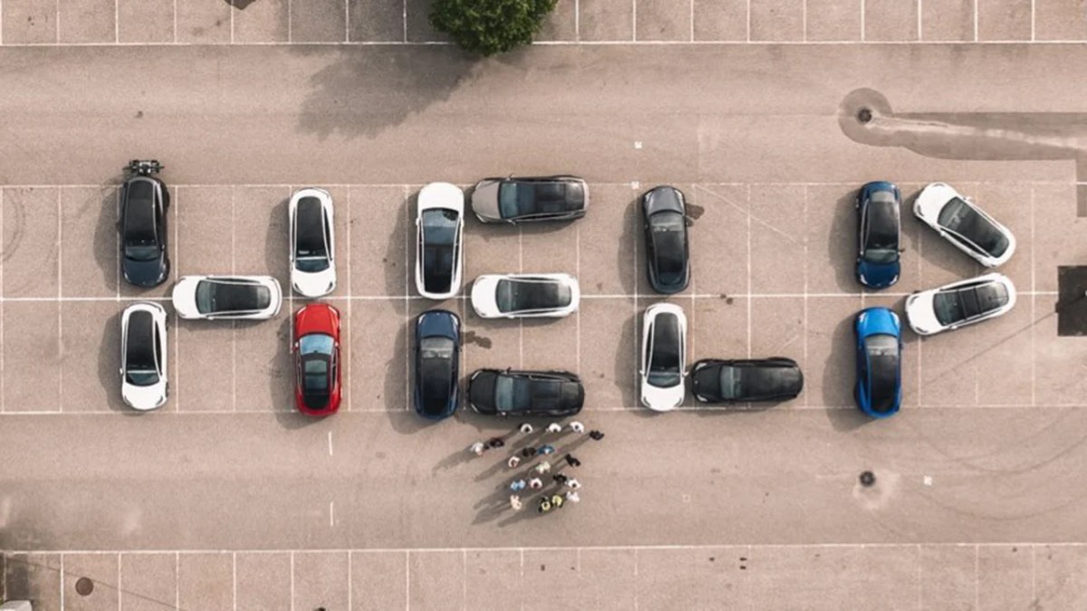 Tesla vehicles arranged to spell 'HELP.'