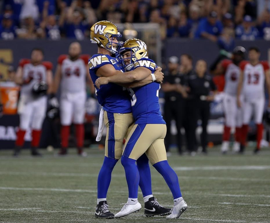 Winnipeg Blue Bombers kicker Marc Liegghio (13), right, celebrates his game winning field goal with quarterback Dakota Prukop (12) against the Ottawa Redblacks during the second half of CFL action in Winnipeg, Friday, June 10, 2022. THE CANADIAN PRESS/John Woods