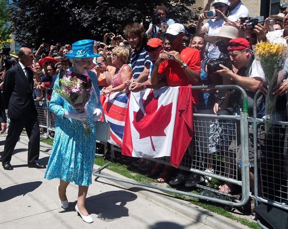 Queen Elizabeth II, right, and Prince Philip the Duke of Edinburgh, left, walk near a crowd of people after attending mass at the Cathedral Church of St.James in Toronto on Sunday, July 4, 2010. THE CANADIAN PRESS/Nathan Denette.