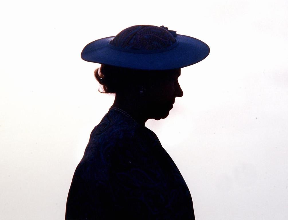 FILE - Britain's Queen Elizabeth II silhouetted during welcoming ceremonies at the airport in Barbados around March 8, 1989.