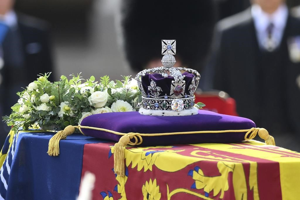 A view of the coffin of Queen Elizabeth II, adorned with a Royal Standard and the Imperial State Crown and pulled by a Gun Carriage of The King's Troop Royal Horse Artillery, during a procession from Buckingham Palace to Westminster Hall in London, Wednesday, Sept. 14, 2022. THE CANADIAN PRESS/AP-Daniel Leal/Pool Photo via AP.