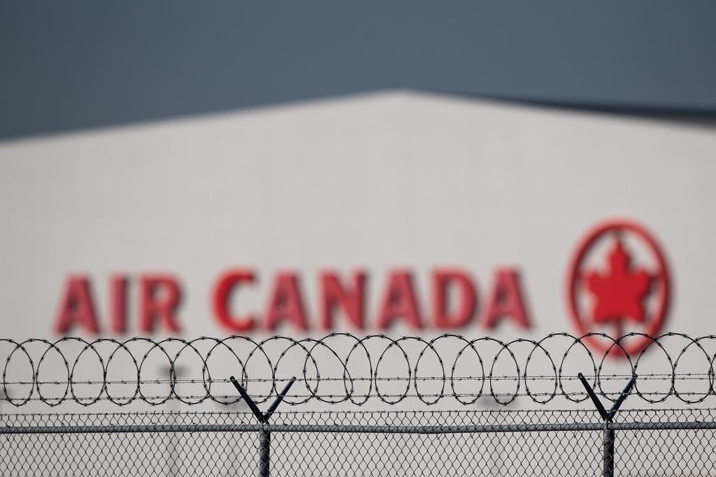 An Air Canada hangar is seen behind a security fence at Vancouver International Airport, in Richmond, B.C., on Friday, March 20, 2020. 