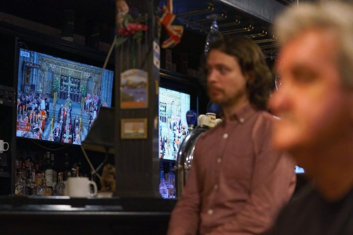 People watch the funeral of Queen Elizabeth on television screens at The Bishop and Belcher pub in Toronto on the morning of Monday, Sept. 19, 2022.