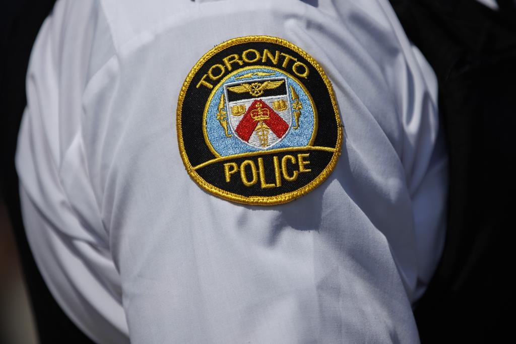 A Toronto Police shoulder patch is shown in Toronto, Friday, Aug. 5, 2022. Police say a 28-year-old man from Toronto has been charged in the deaths of two people found in an apartment building in the city on Wednesday. THE CANADIAN PRESS/Cole Burston.