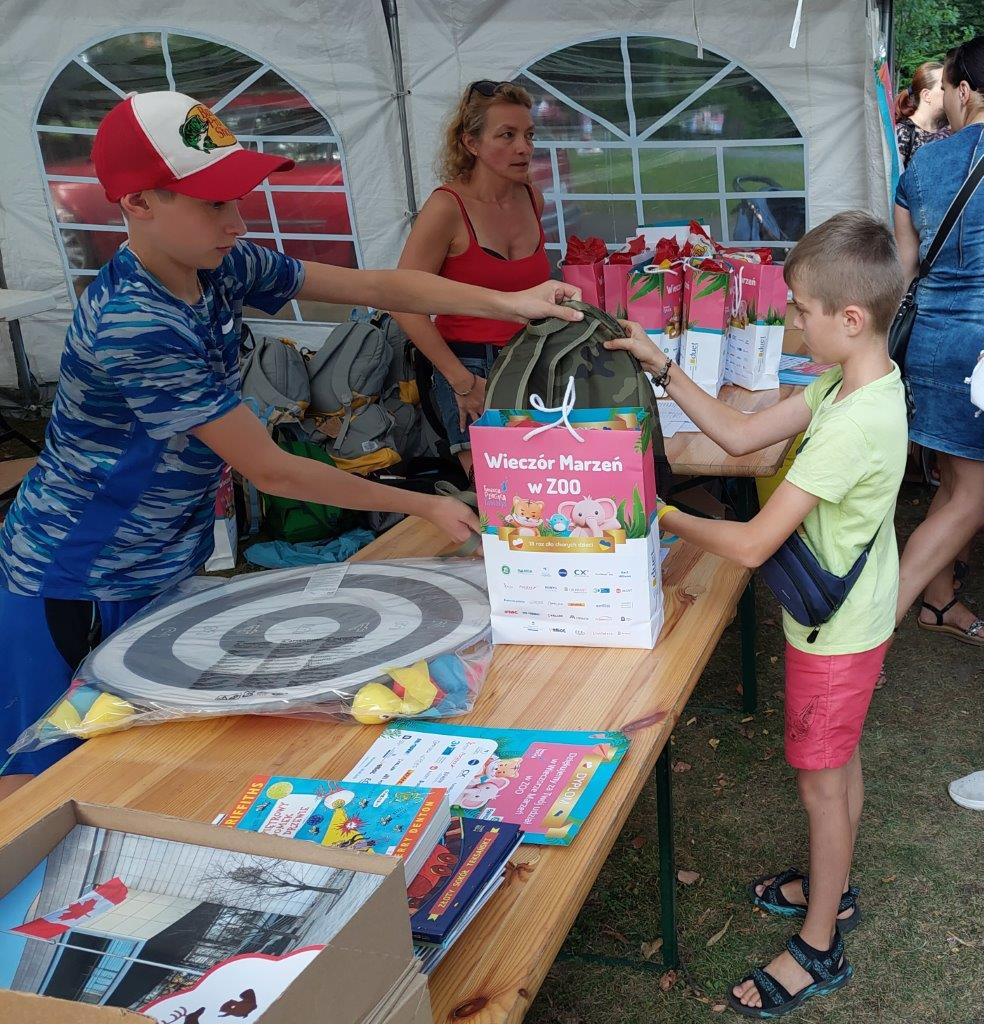 Oscar Oliver handing backpack and gifts to a young Ukrainian refugee.