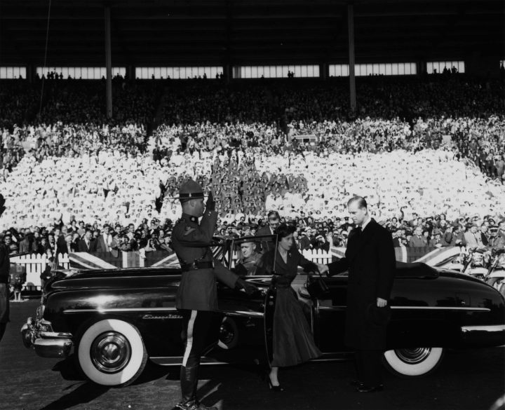 Princess Elizabeth is assisted by Philip, Duke of Edinburgh, as they leave their car as they tour the Canadian Exhibition grounds in Toronto on October 13, 1951.