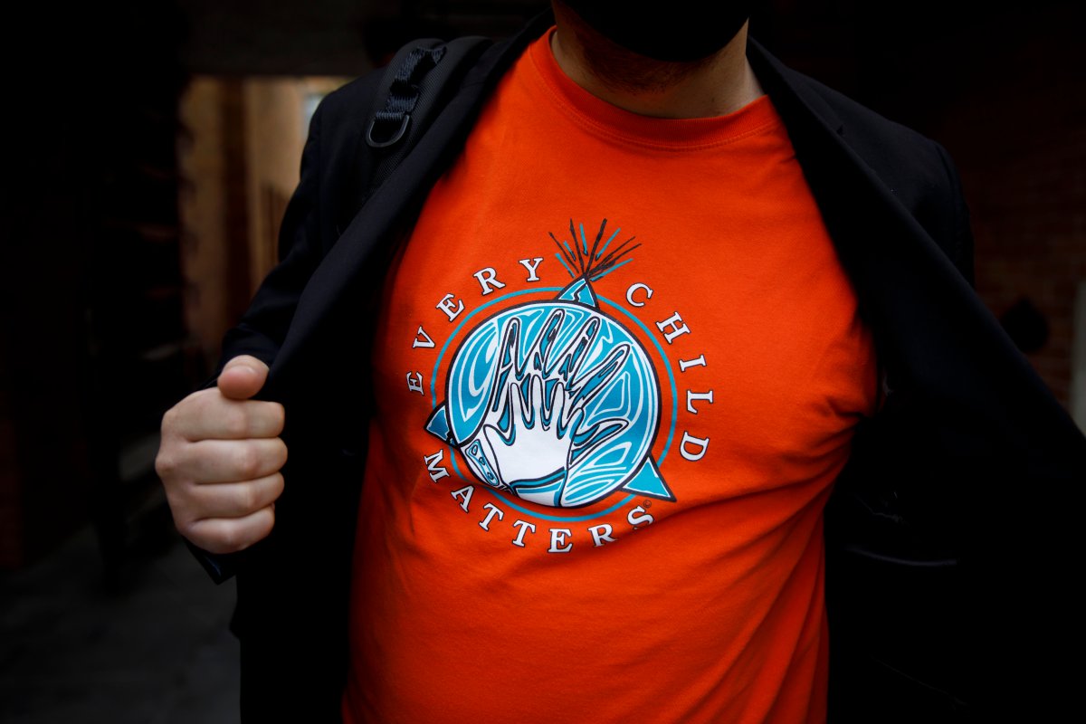 A man shows off an orange shirt at an event to mark Canada’s Truth and Reconciliation Day in 2021.