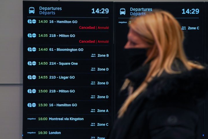 A passenger walks by a departures board showing two cancelled trips at the new Union Station GO Transit Bus Terminal in Toronto on Tuesday, November 2, 2021. Nearly 100 bus trips were cancelled in the Toronto and Hamilton areas on Monday as the Metrolinx transit agency began to place staff unvaccinated against COVID-19 on unpaid leave. 