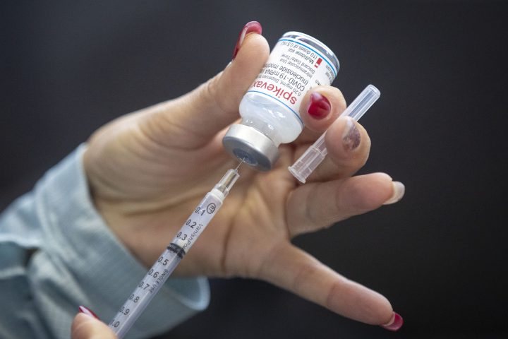 A person draws out Moderna vaccine during a drive through COVID-19 vaccine clinic at St. Lawrence College in Kingston, Ontario, on Sunday January 2, 2022..