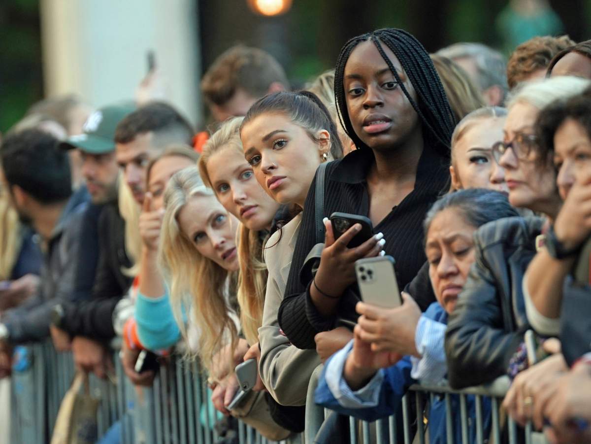 People gather outside Buckingham Palace following the announcement of the death of Queen Elizabeth II, in London, Thursday, Sept. 8, 2022. (Yui Mok/PA via AP)