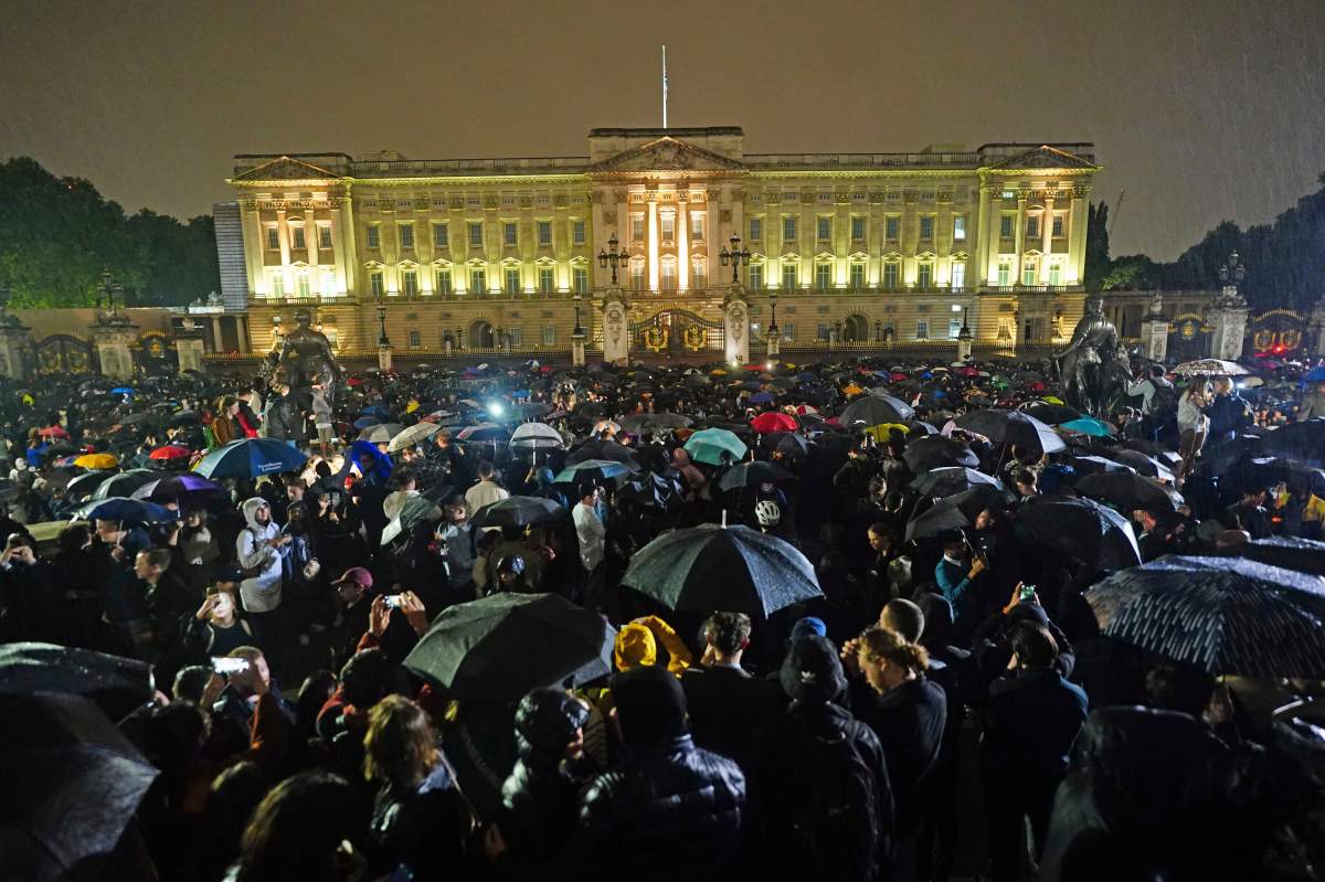 People gather outside Buckingham Palace following the announcement of the death of Queen Elizabeth II, in London, Thursday, Sept. 8, 2022.
