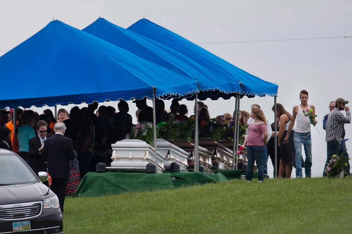 In this May 3, 2016, file photo, mourners gather around caskets for six of the eight members of the Rhoden family found shot April 22, 2016.