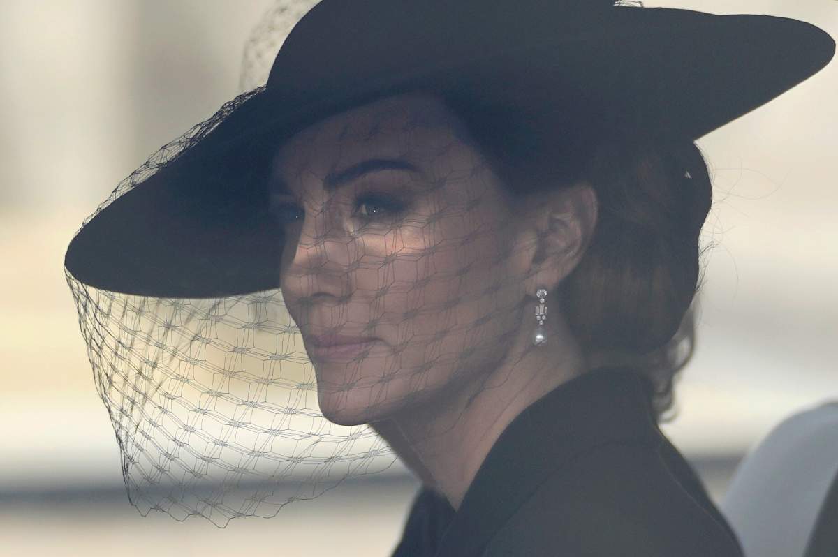 Kate, Princess of Wales, sits in a car following behind the coffin of Queen Elizabeth II being carried along The Mall in London, on its way to Windsor Castle, Monday, Sept. 19, 2022. (AP Photo/Markus Schreiber, Pool)