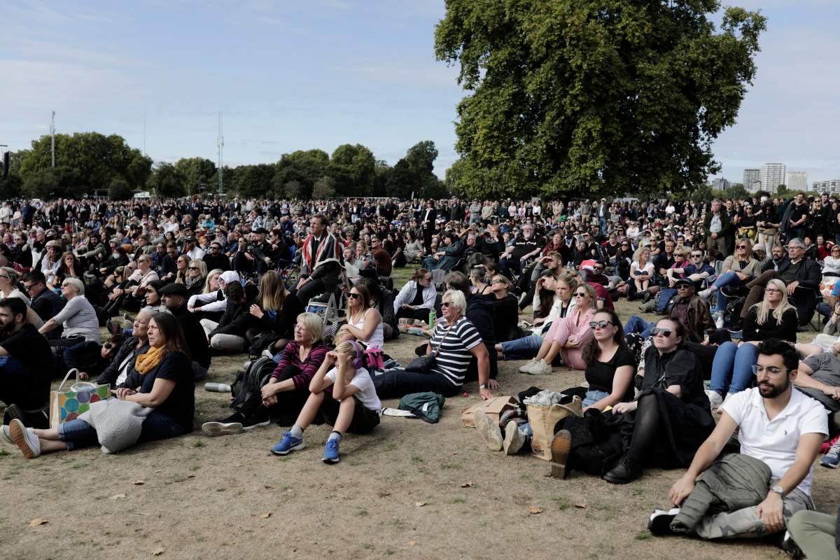 People watch the state funeral service of Britain’s Queen Elizabeth II on giant screens, Monday, Sept. 19, 2022 in London in Hyde Park. (AP Photo/Lewis Joly)