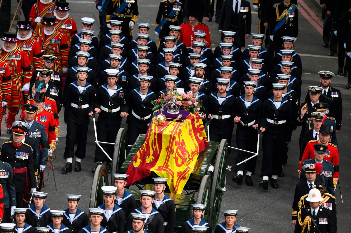 Royal Navy Sailors walk ahead and behind the coffin of Queen Elizabeth II, draped in the Royal Standard, as it travels on the State Gun Carriage of the Royal Navy at Wellington Arch in London, Monday Sept. 19, 2022.